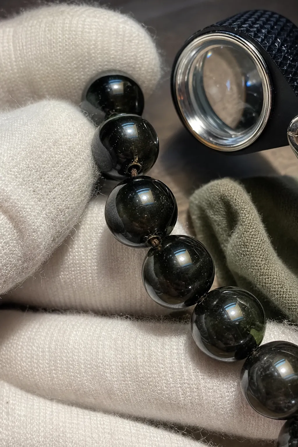 Close inspection of bead drill holes and surface wear on dark polished crystal beads