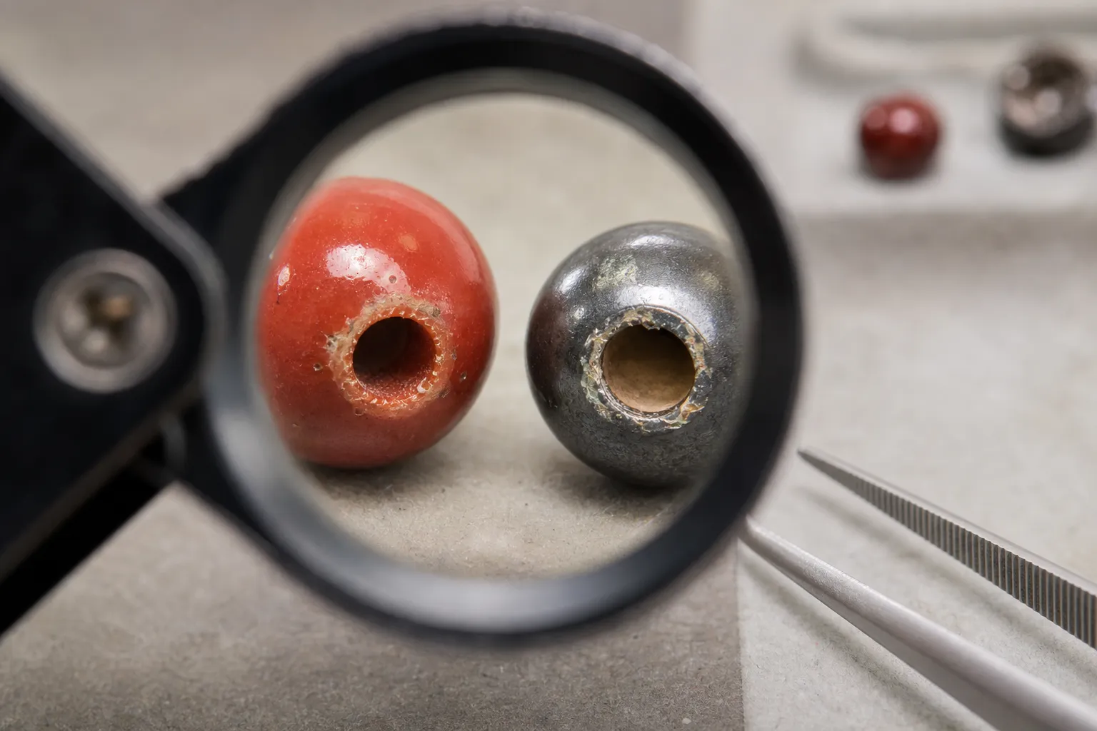 Close inspection of bead-hole wear showing coating chips and different interior colors as suggestive clues
