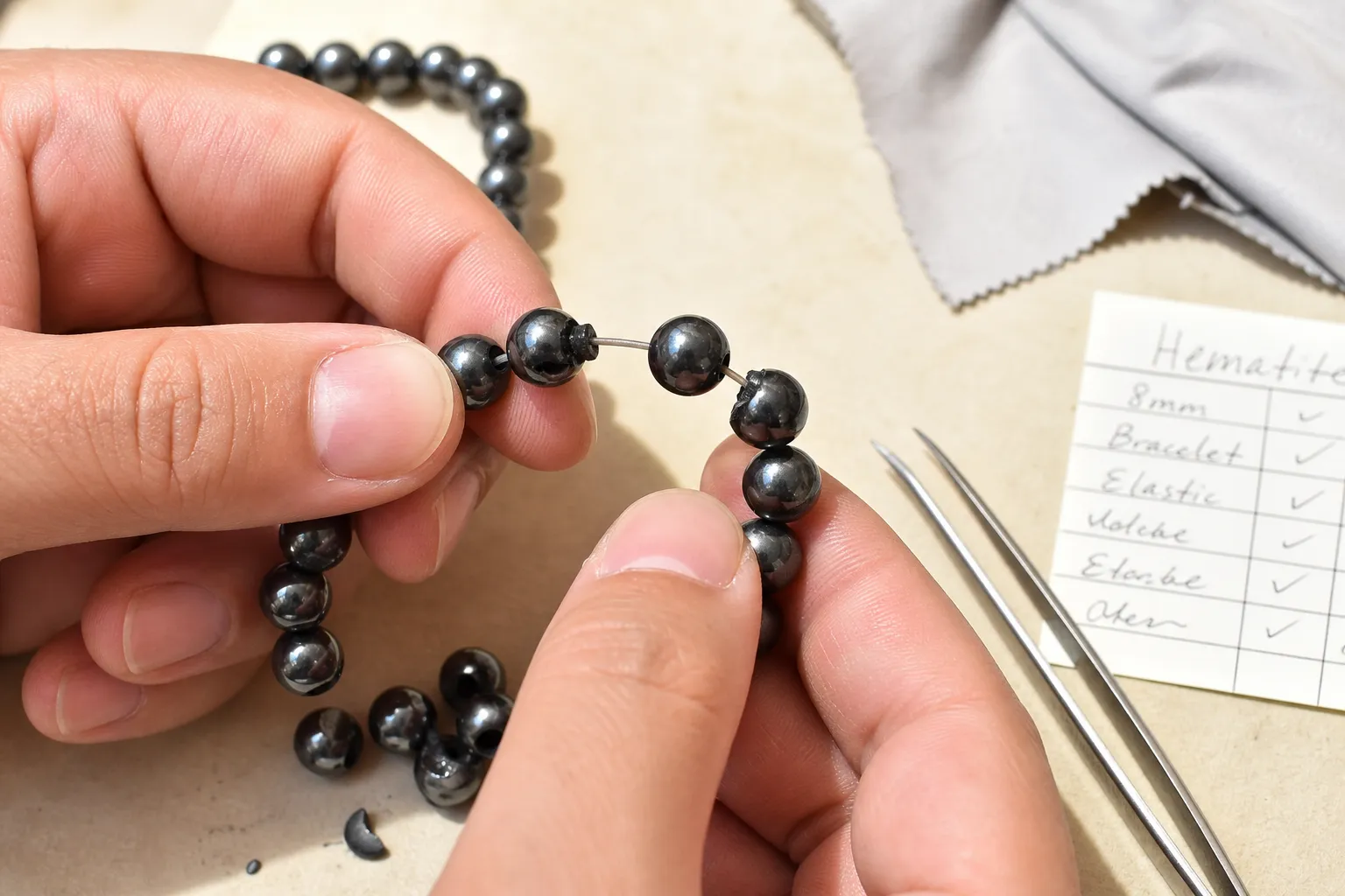 Close inspection of hematite bracelet beads, elastic, drill holes, and loose pieces before wearing