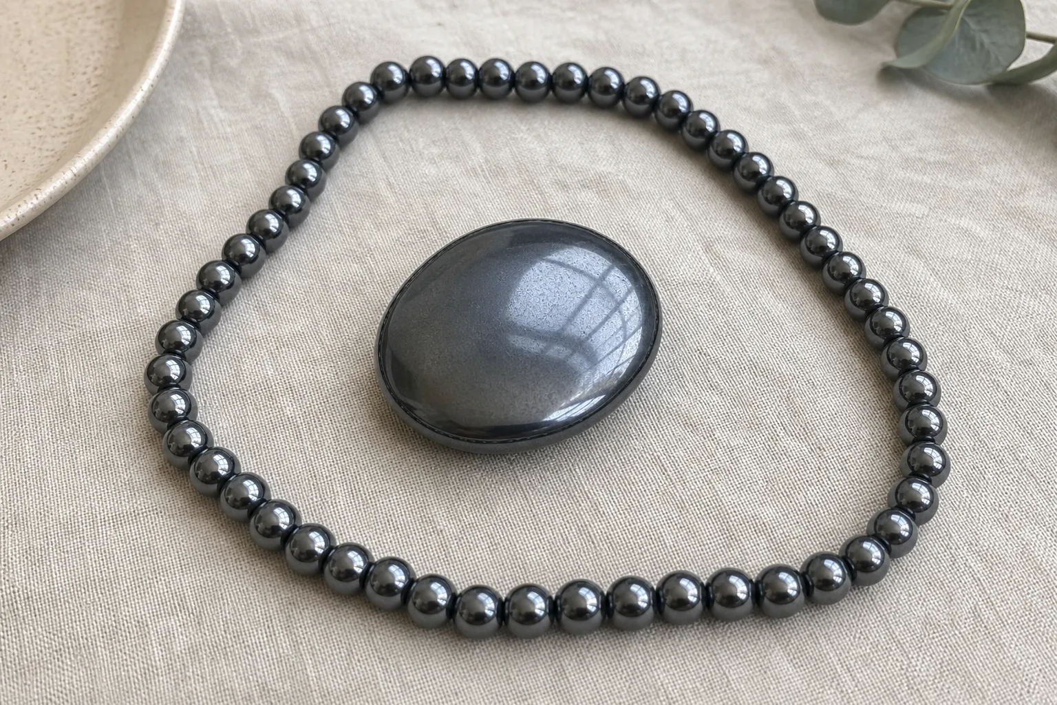Hematite beads and a smooth stone arranged to compare outward boundary language with inward grounding language