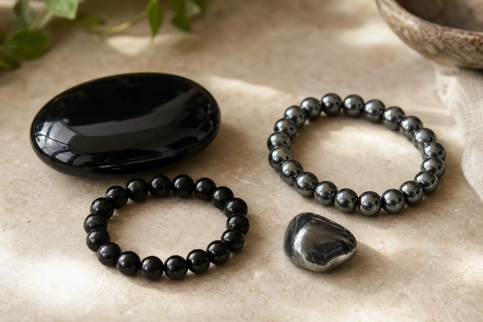Black obsidian and hematite shown side by side for comparing symbolic protection language and material feel