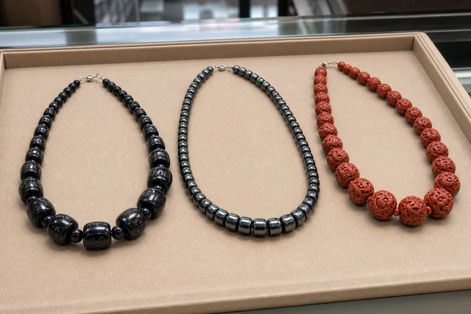 Obsidian, hematite, and cinnabar-style necklaces arranged for near-skin contact comparison