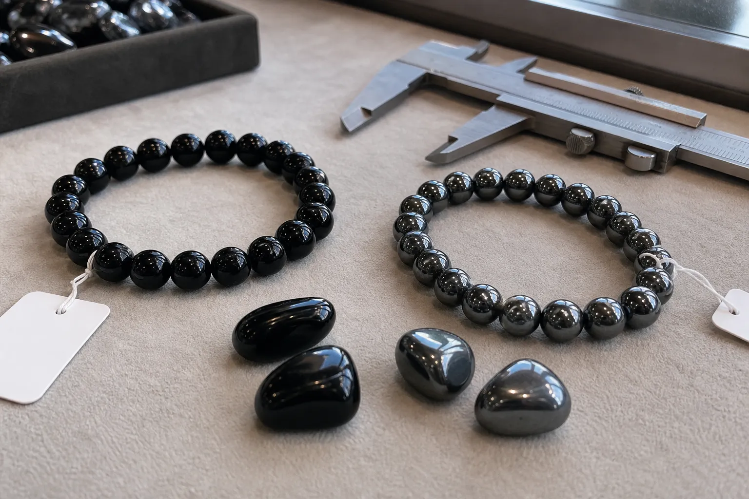 Black obsidian beads and gunmetal hematite beads compared by shine and weight cues