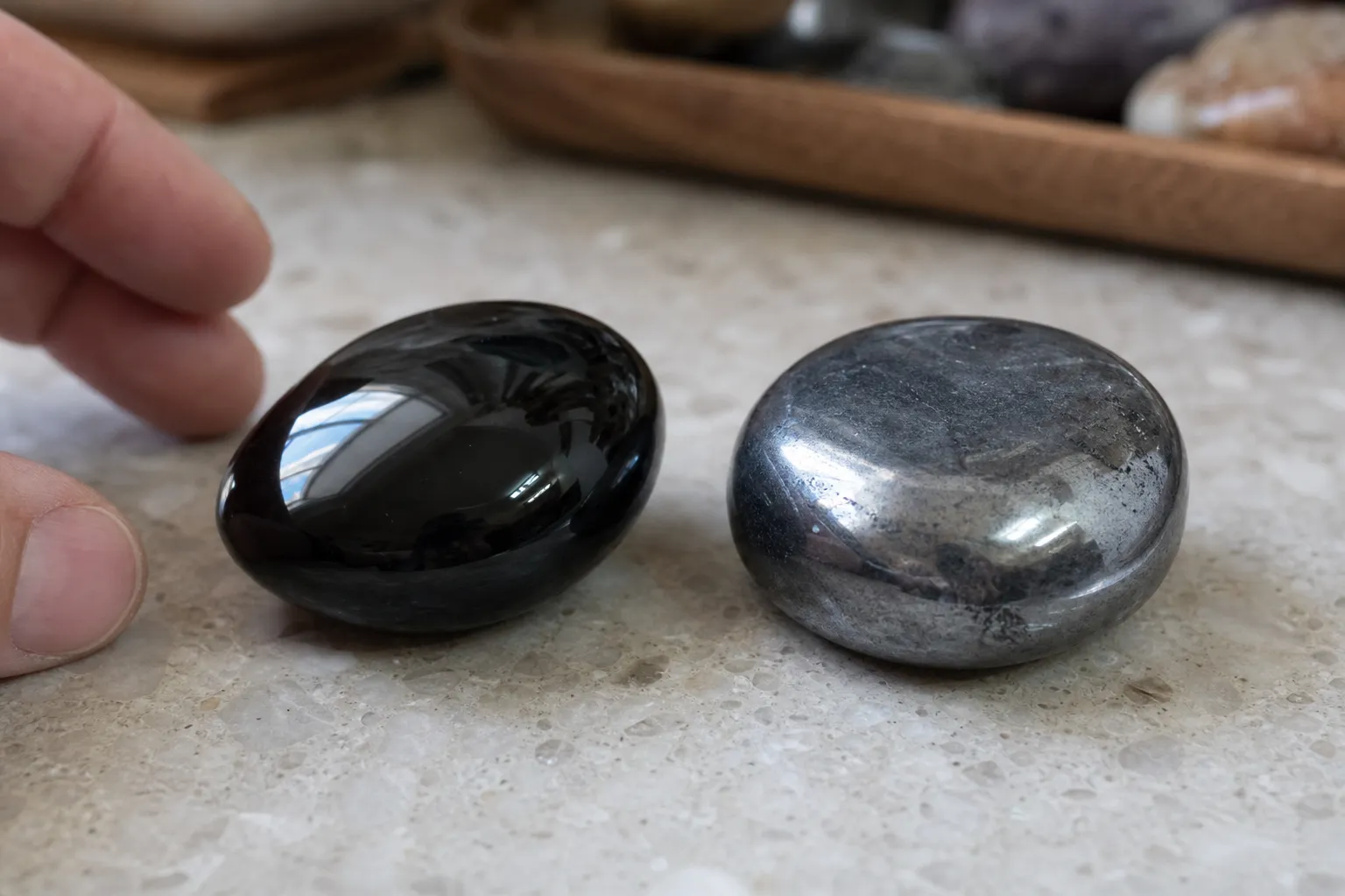 Polished black obsidian beside metallic gray hematite for buyer comparison