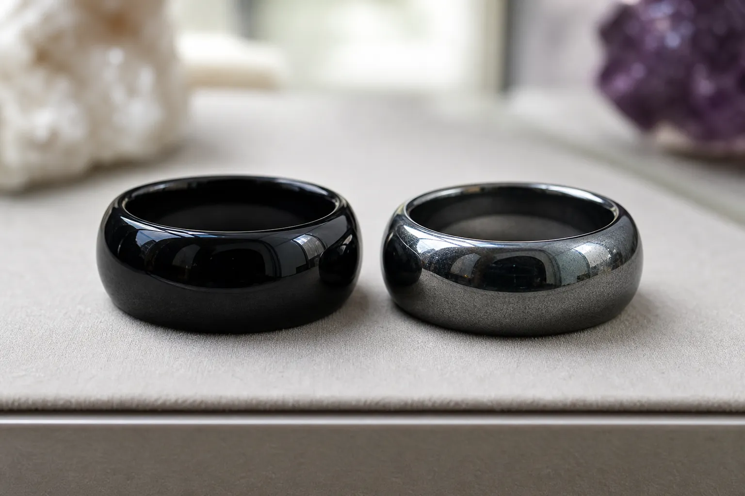 Obsidian and hematite rings shown side by side to compare black glassy polish with metallic grey mineral shine